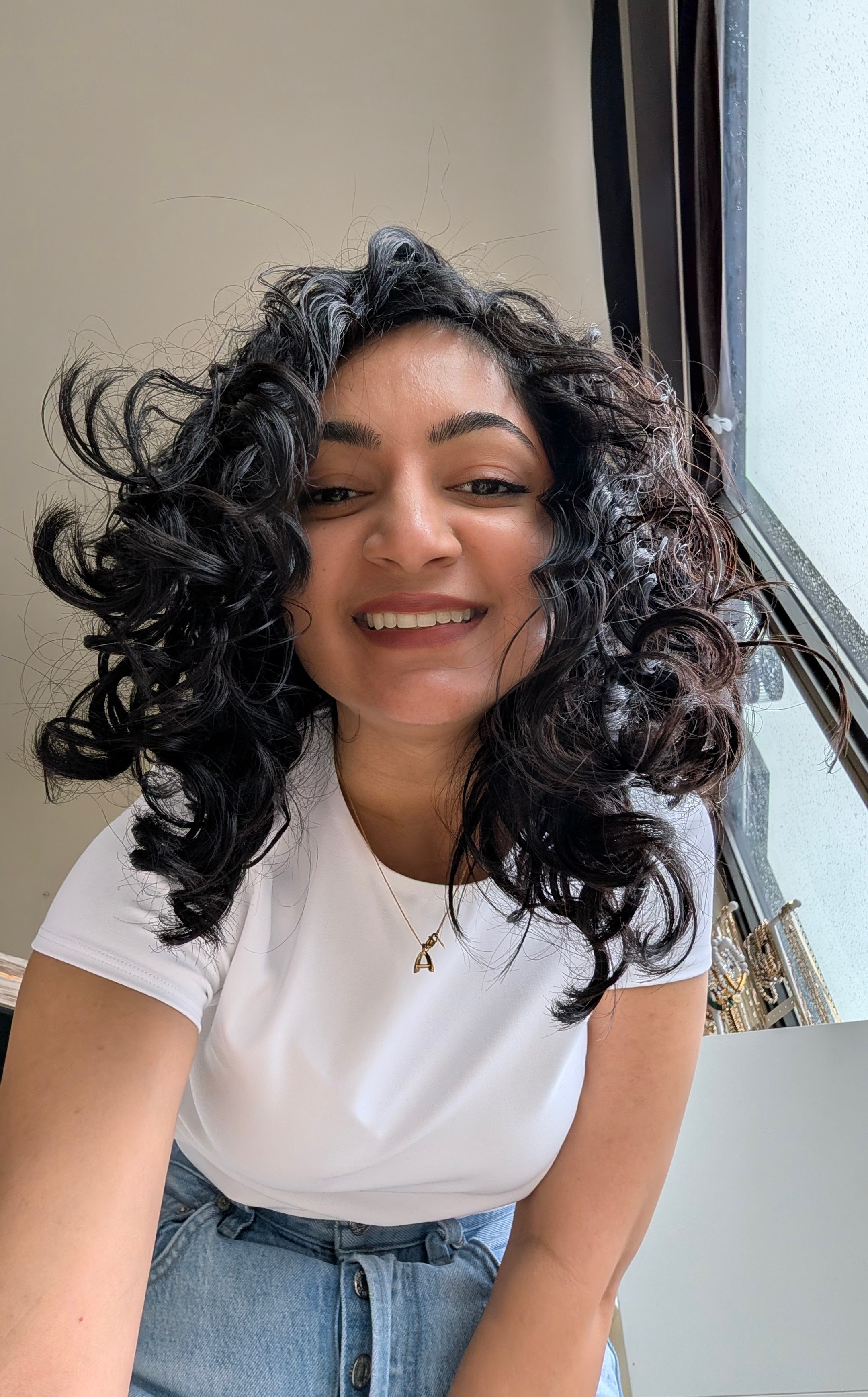 Arshia Garg smiling in a white tee and jeans